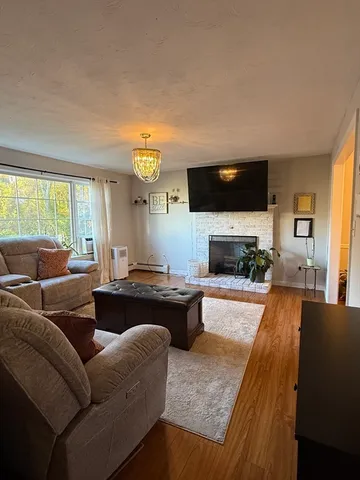 a living room with furniture a flat screen tv and a fireplace