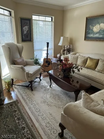 a living room with furniture wooden floor and a large window