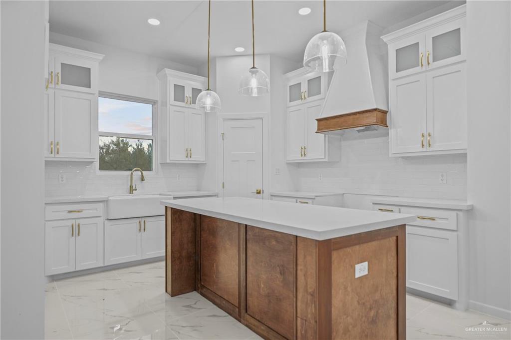 2732 East Conroe Road Edinburg, TX 78542 - Photo 4 of 15 a kitchen with a sink dishwasher a stove and white cabinets with wooden floor