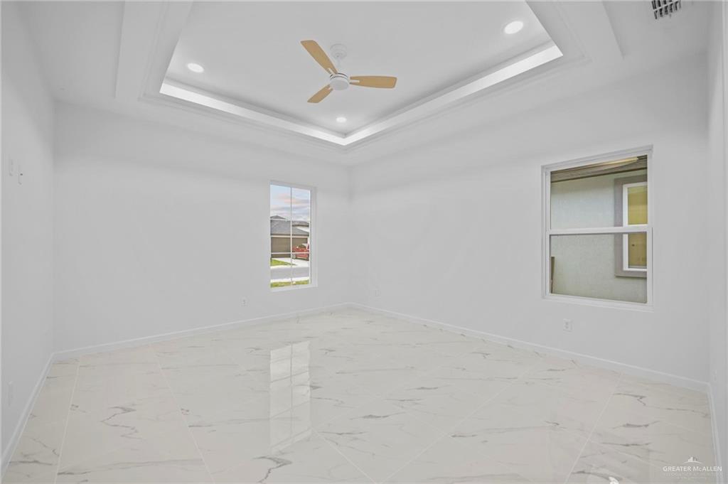 2732 East Conroe Road Edinburg, TX 78542 - Photo 7 of 15 an empty room with windows and ceiling fan
