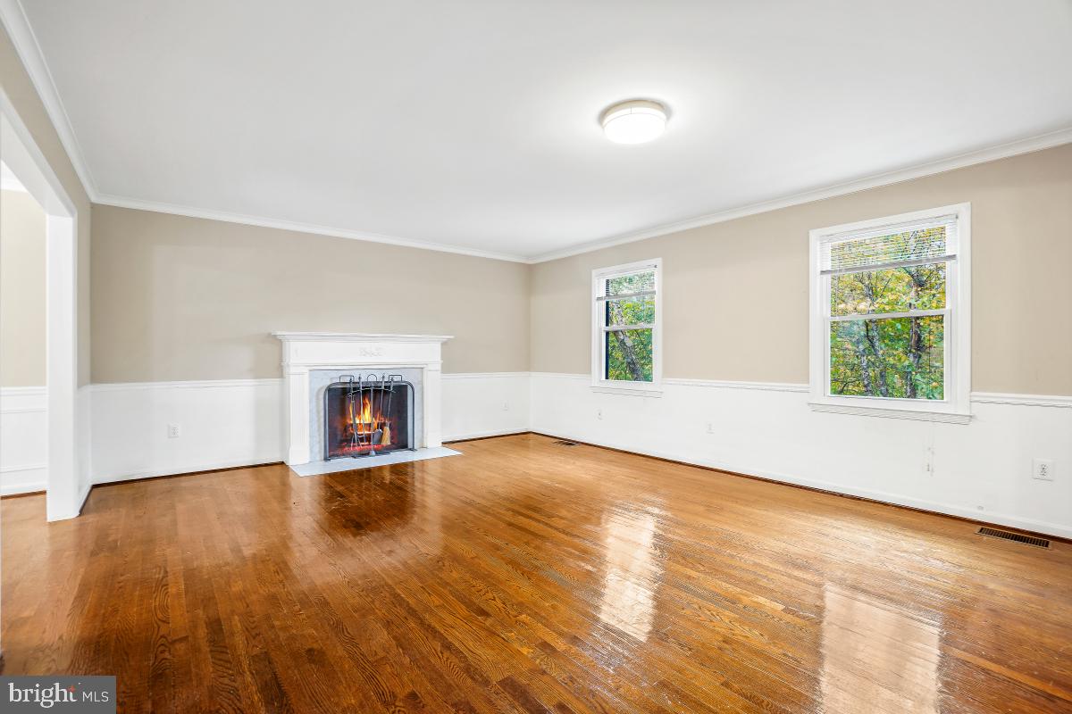 6871 Churchill Road McLean, VA 22101 - Photo 5 of 30 an empty room with wooden floor and fireplace