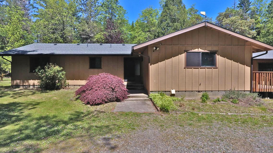 922 Garner Road Cave Junction, OR 97523 - Photo 1 of 24 a front view of a house with garden