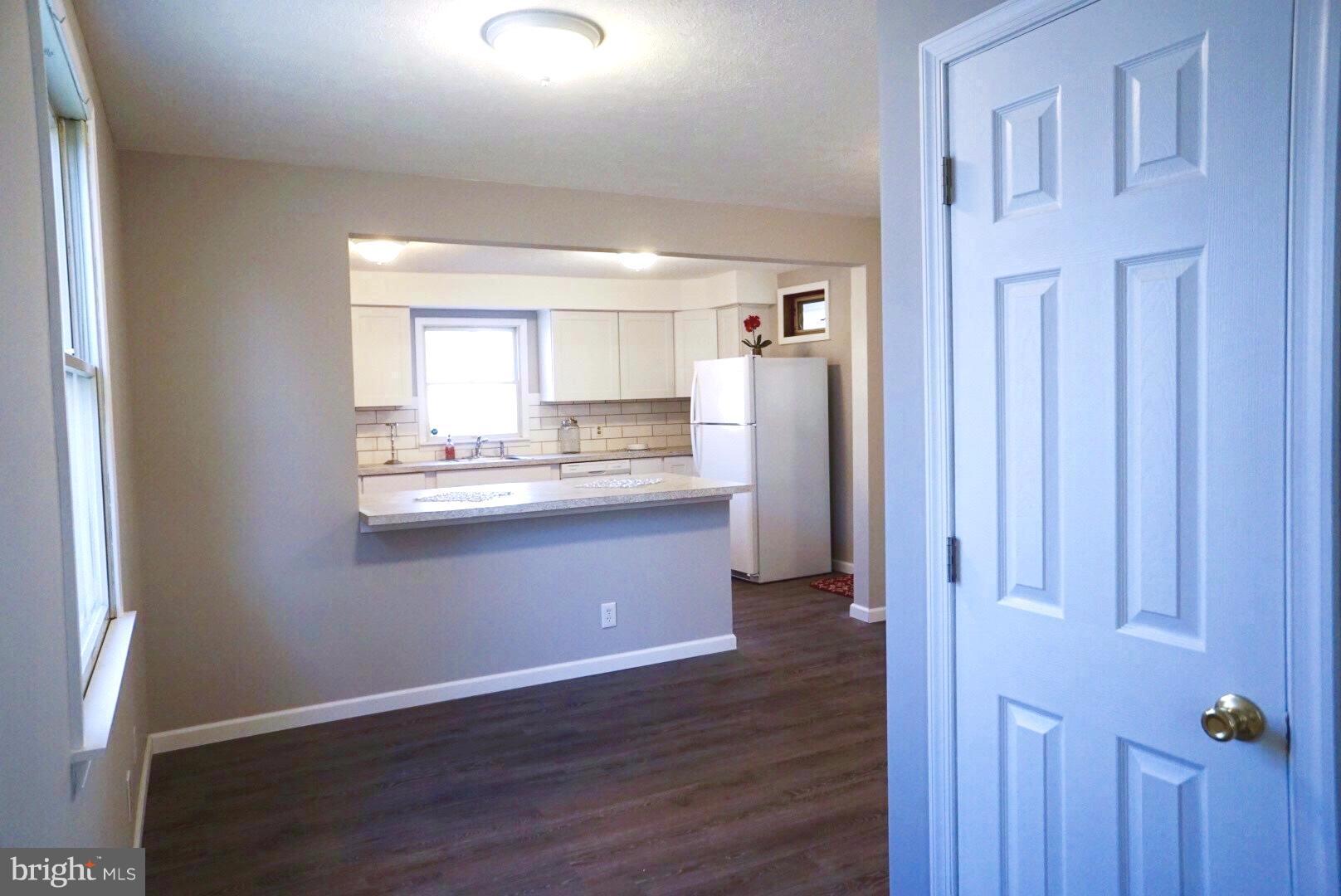 8244 Cornwall Road Baltimore, MD 21222 - Photo 4 of 30 a kitchen with kitchen island wooden cabinets and refrigerator