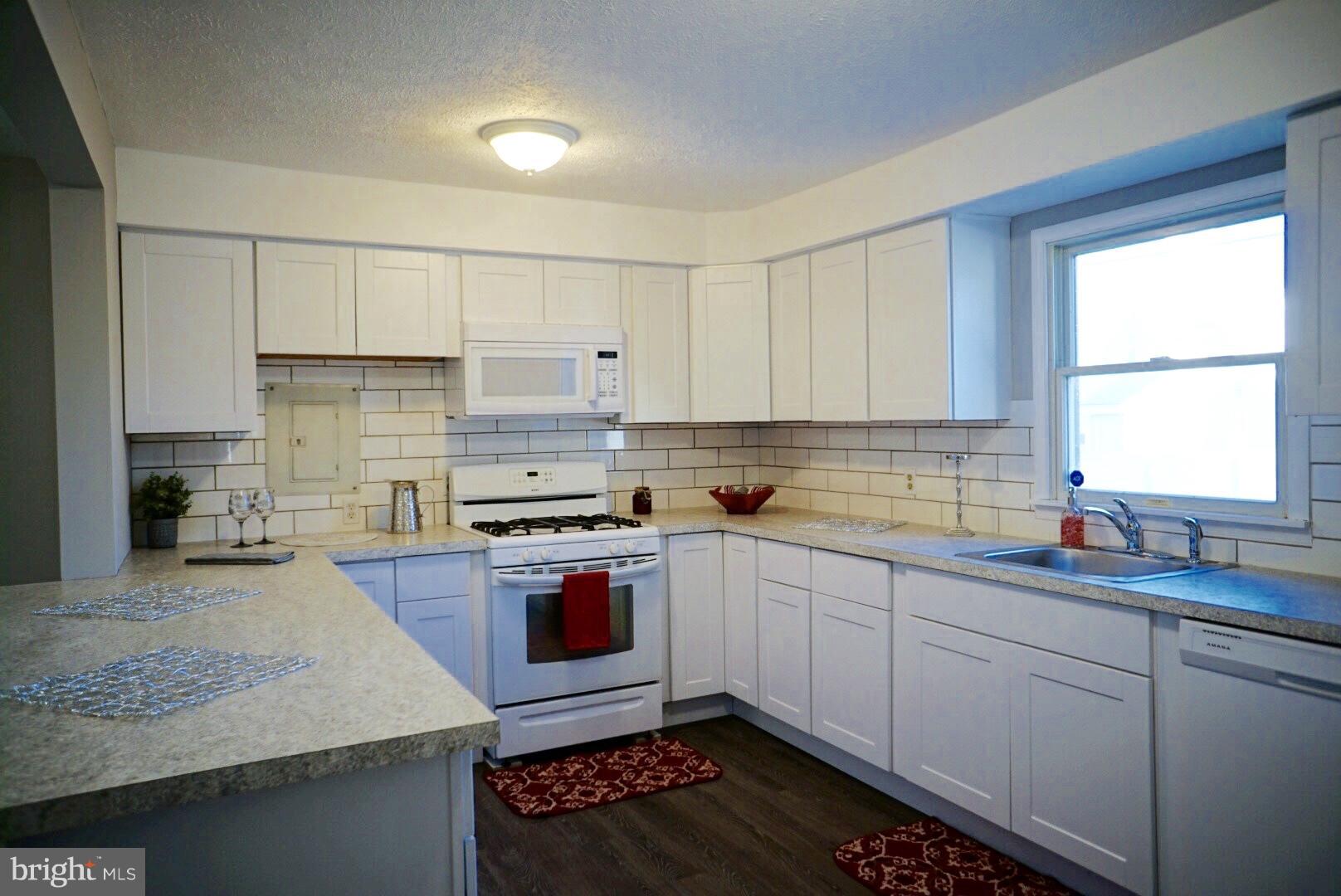 8244 Cornwall Road Baltimore, MD 21222 - Photo 6 of 30 a kitchen with kitchen island granite countertop a sink stove and cabinets