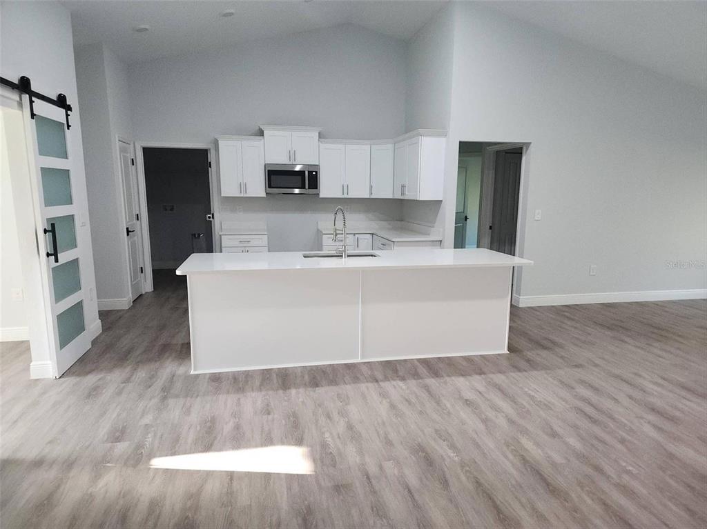 1111 Dagmar Avenue Spring Hill, FL 34606 - Photo 5 of 27 a view of a kitchen with wooden floor and electronic appliances