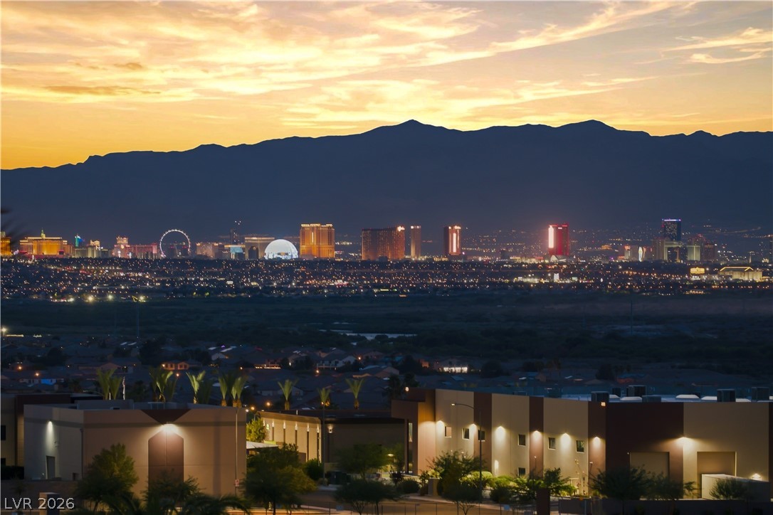 1068 Calico Ridge Drive Henderson, NV 89011 - Photo 37 of 38 Distant ridge lines and twinkling city lights create a dramatic backdrop under the twilight sky.