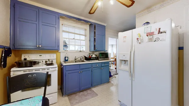 a kitchen with a refrigerator a stove a sink and cabinets