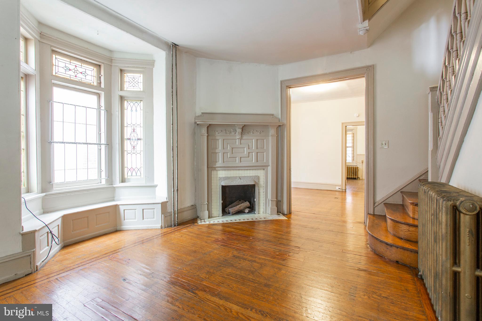 wooden floor fireplace and windows in an empty room