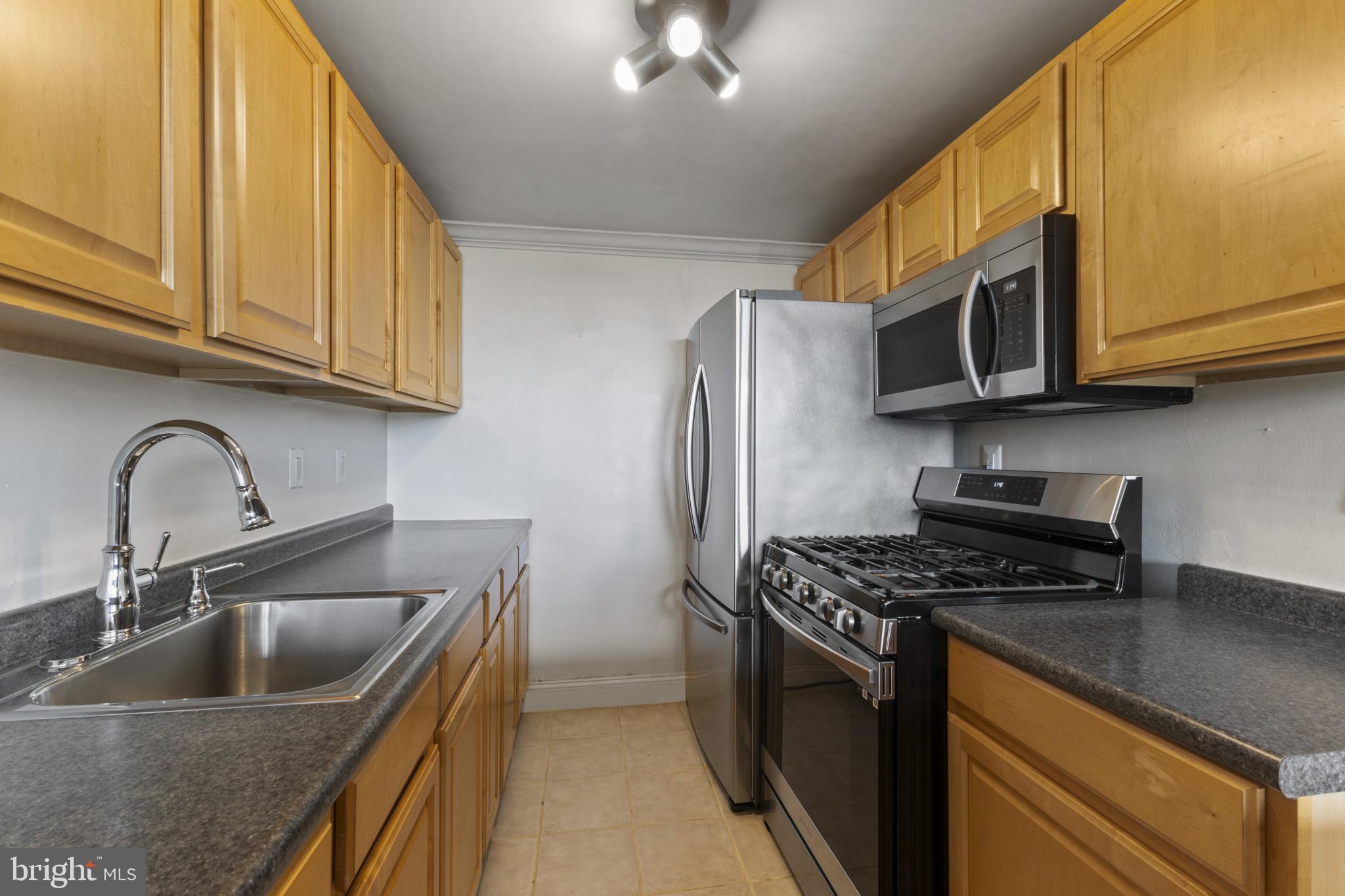 4600 Duke Street, Unit 613 Alexandria, VA 22304 - Photo 12 of 32 a kitchen with stainless steel appliances granite countertop a sink stove and cabinets