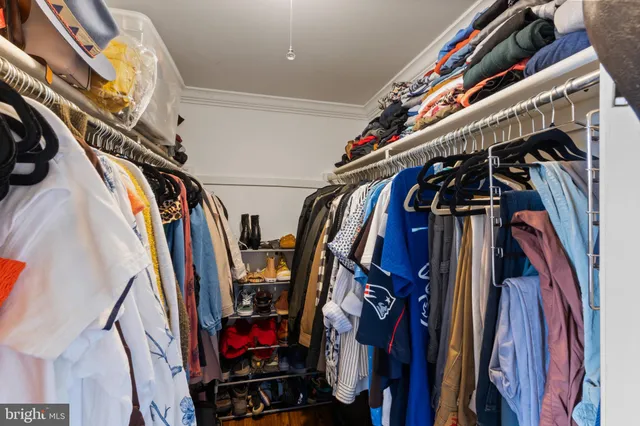 a view of walk in closet with clothes and shoes