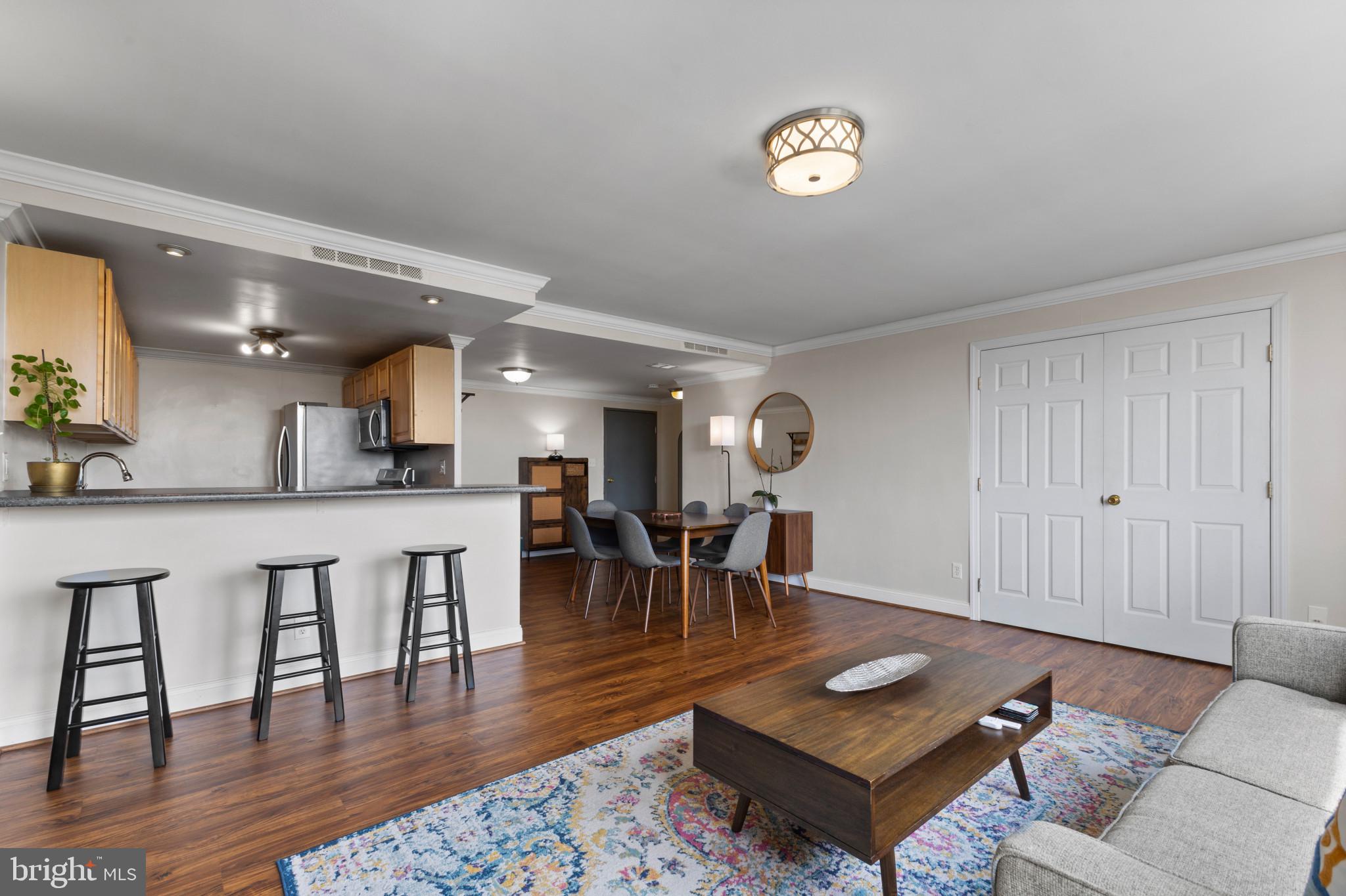 4600 Duke Street, Unit 613 Alexandria, VA 22304 - Photo 5 of 32 a living room with furniture and a dining table with wooden floor