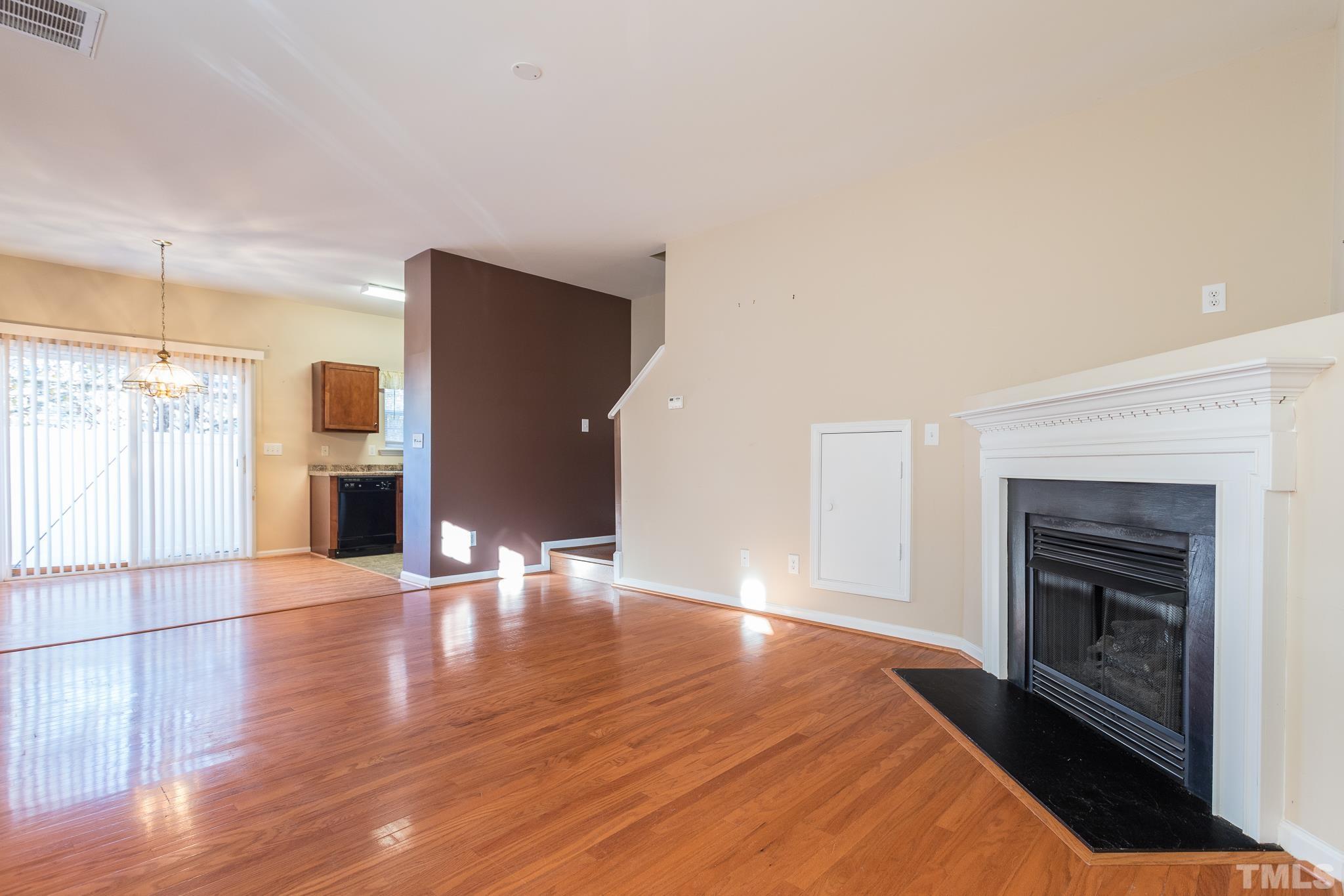 2153 Metacomet Way Raleigh, NC 27604 - Photo 7 of 30 a view of empty room with wooden floor and fireplace
