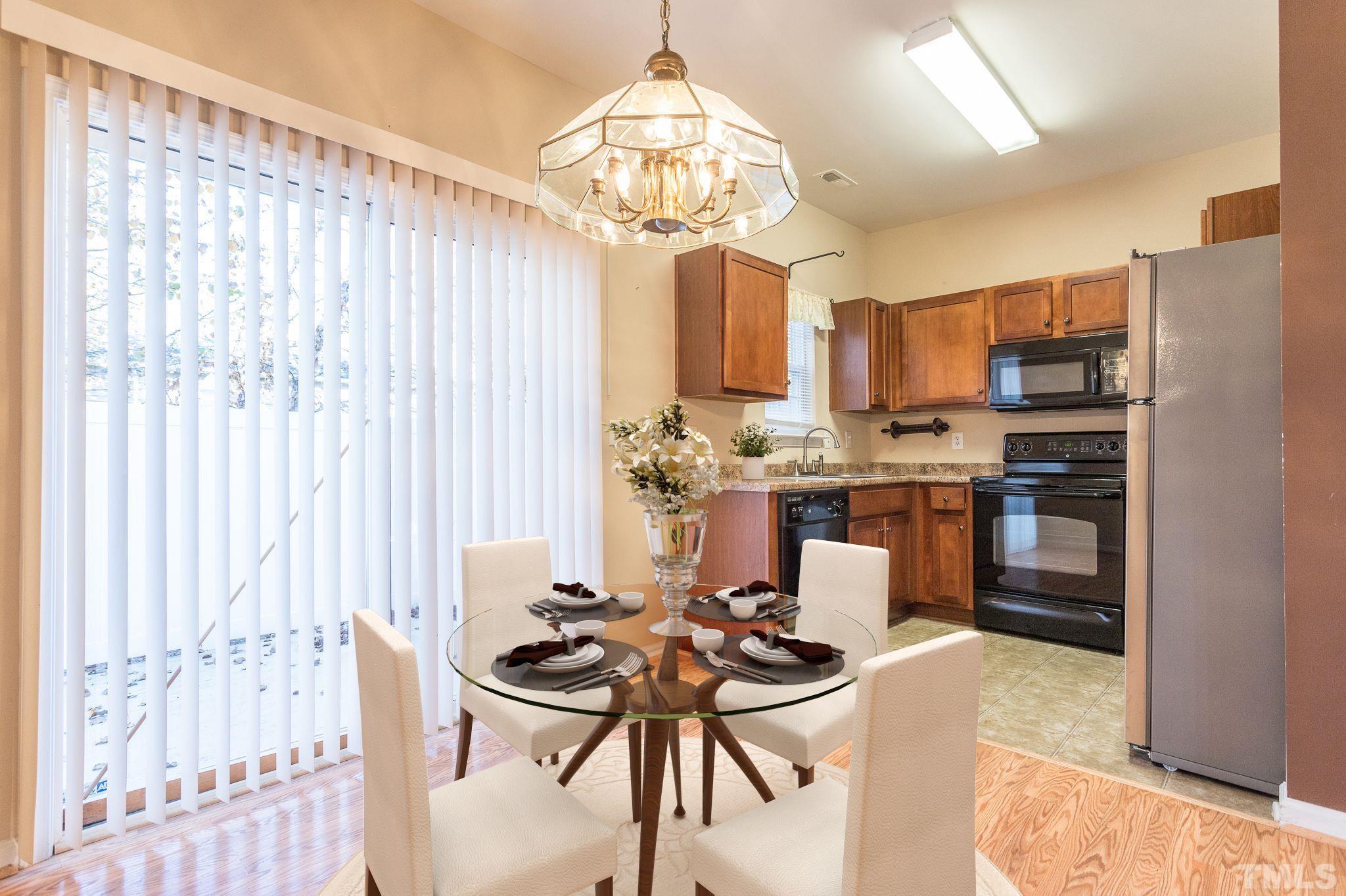 2153 Metacomet Way Raleigh, NC 27604 - Photo 9 of 30 a kitchen with stainless steel appliances a dining table and chairs