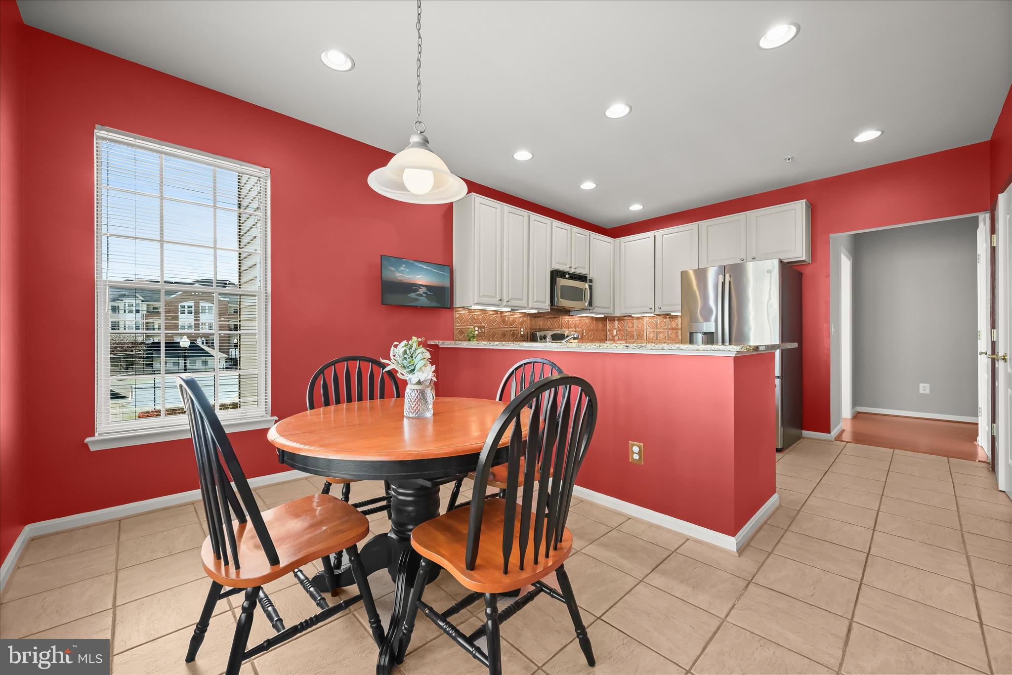 7305 Maplecrest Road, Unit 207 Elkridge, MD 21075 - Photo 13 of 50 a dining room with stainless steel appliances kitchen island granite countertop a dining table chairs and a refrigerator