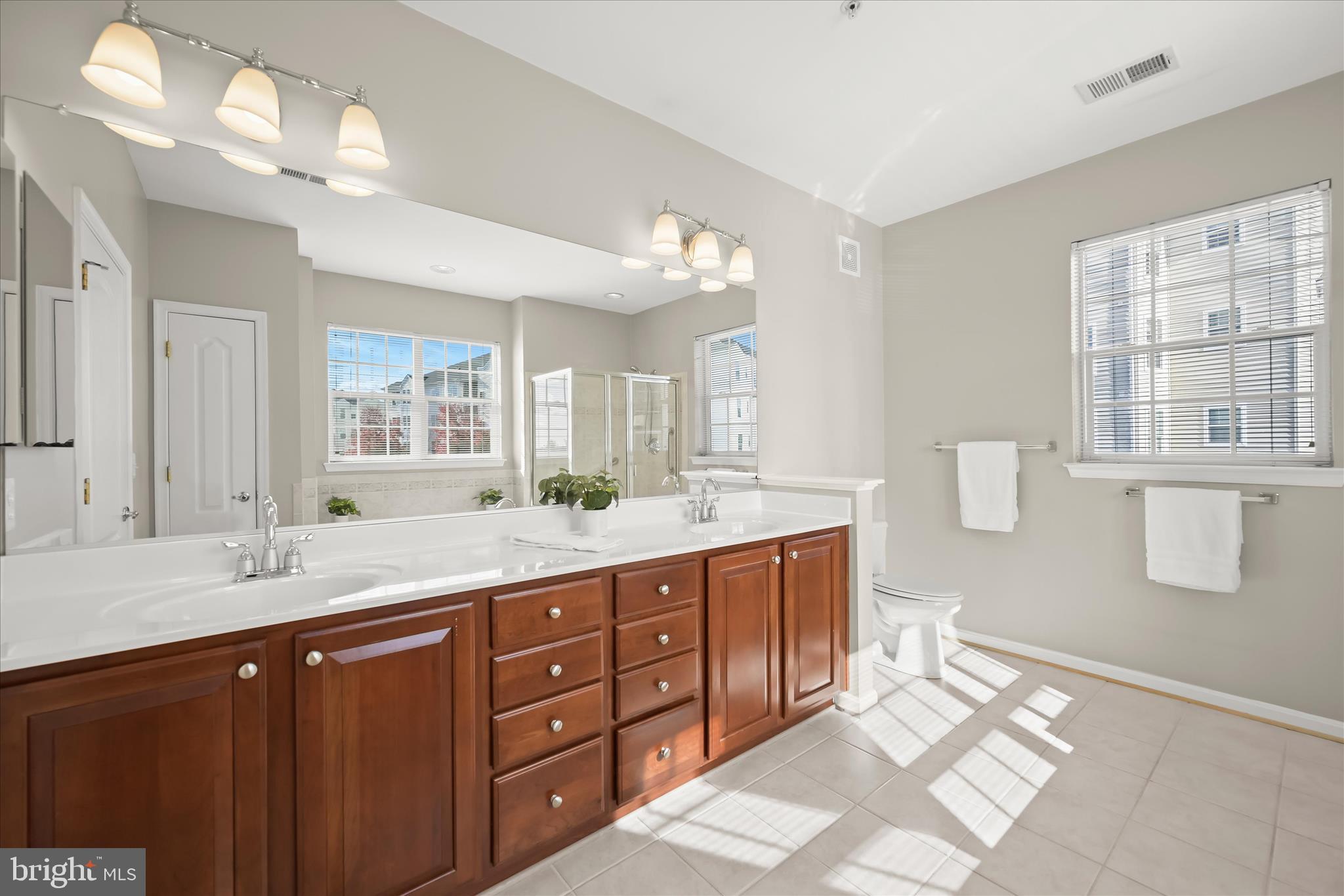 7305 Maplecrest Road, Unit 207 Elkridge, MD 21075 - Photo 26 of 50 a bathroom with a granite countertop double vanity sink a mirror and a shower