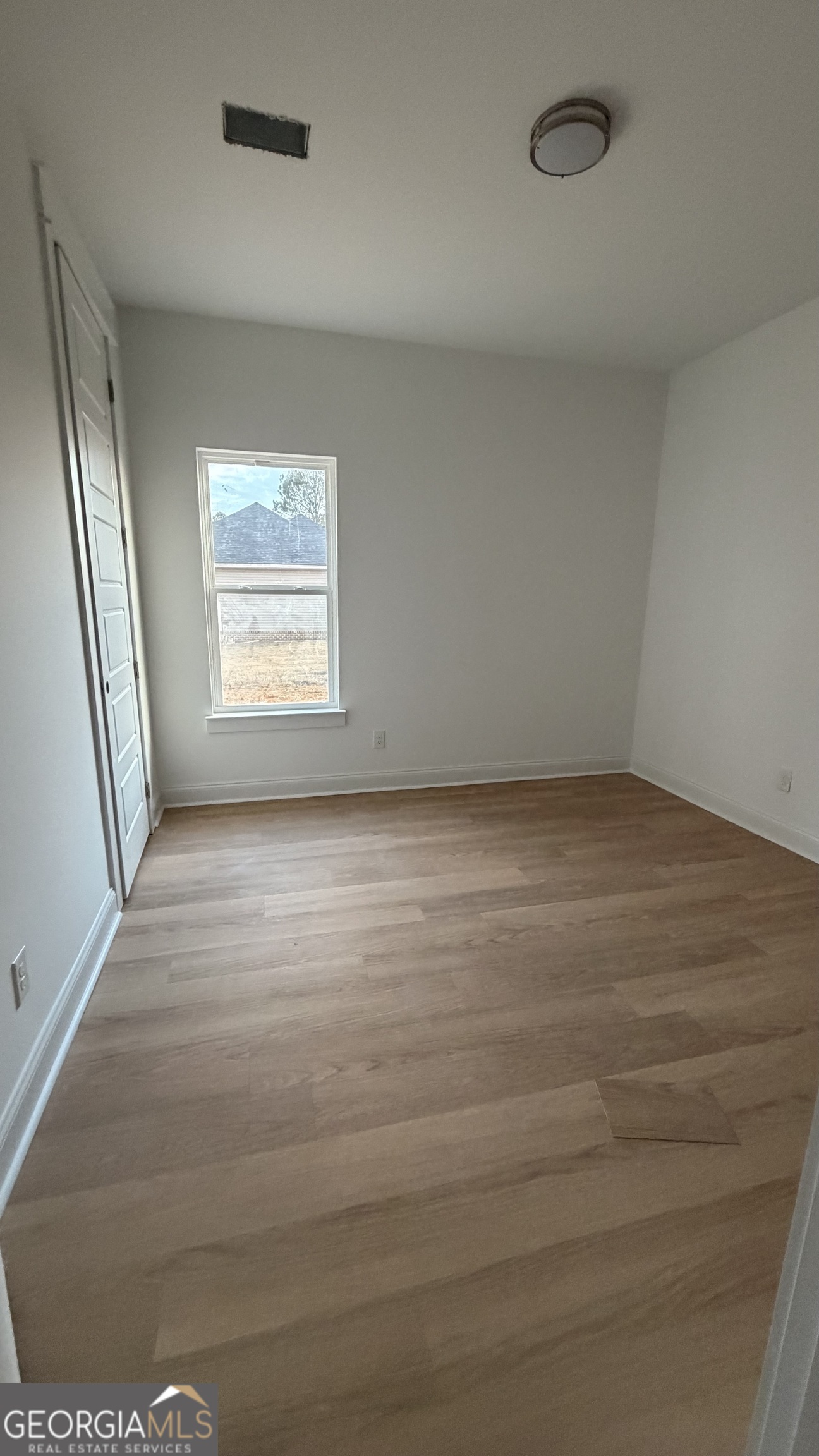 336 Mace Cannon Road Dublin, GA 31021 - Photo 8 of 18 an empty room with wooden floor and windows