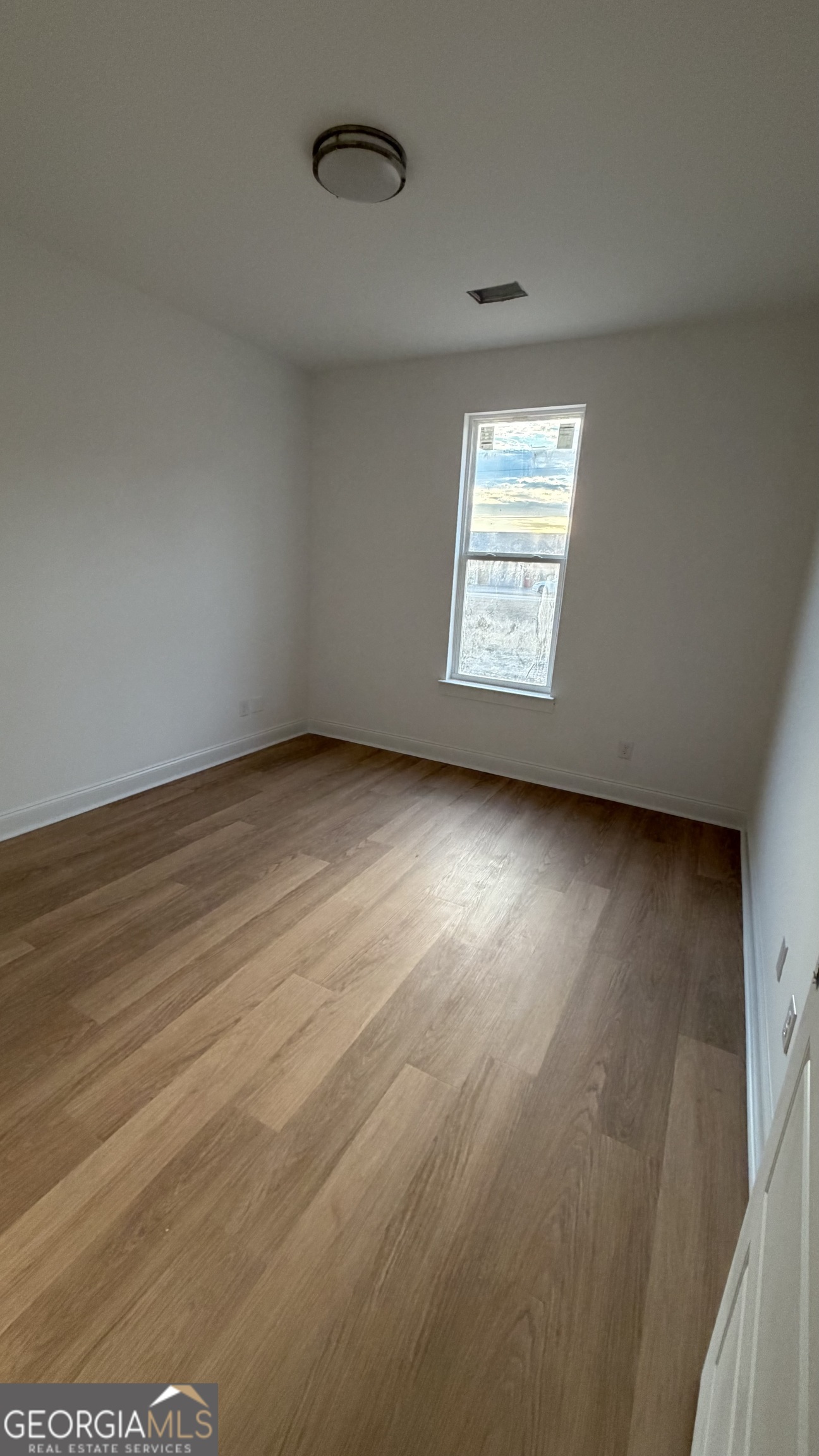 336 Mace Cannon Road Dublin, GA 31021 - Photo 10 of 18 an empty room with wooden floor and windows