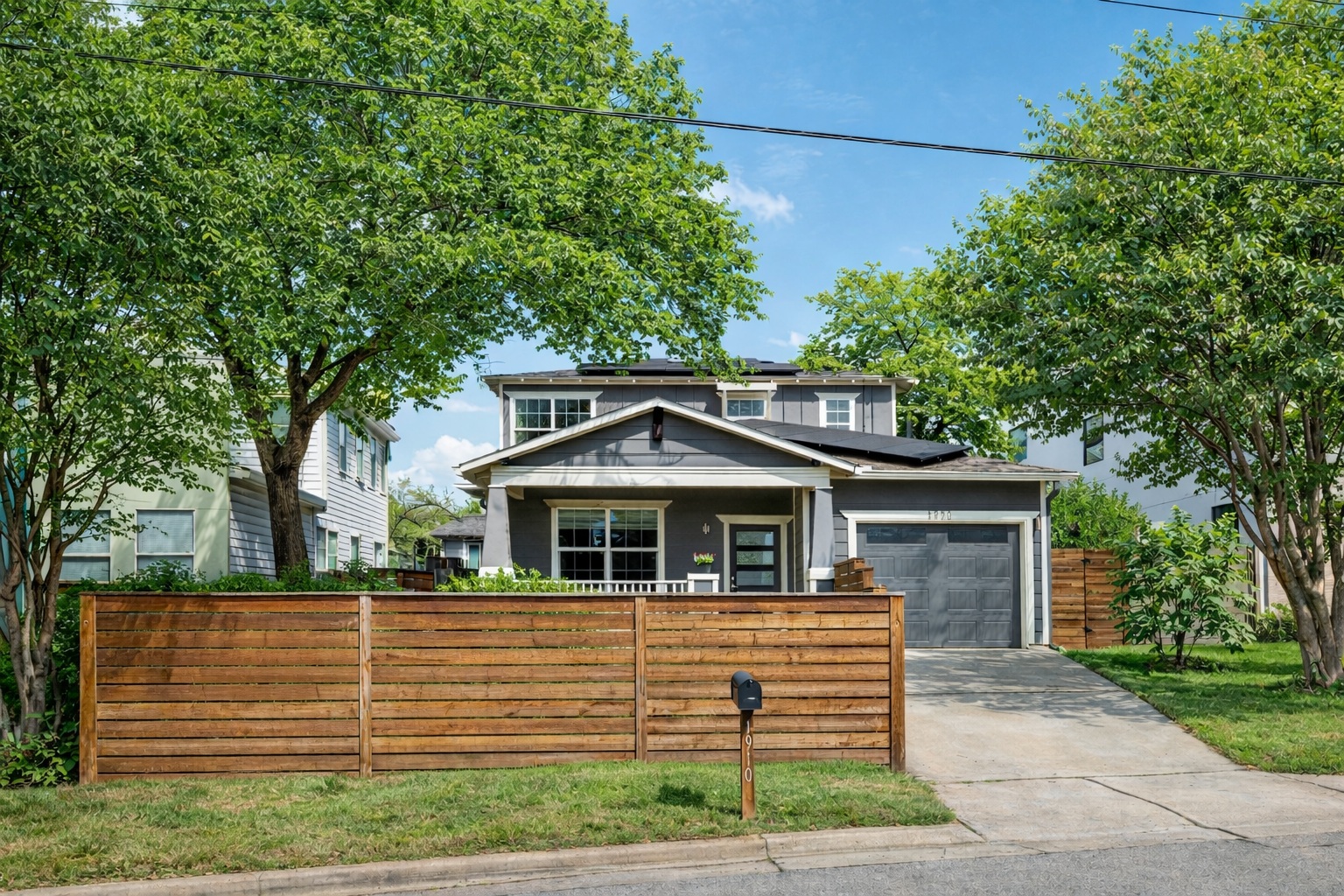 1910 East 10th Street Austin, TX 78702 - Photo 1 of 1 Front of home featuring a fenced front yard, solar panels, and a garage