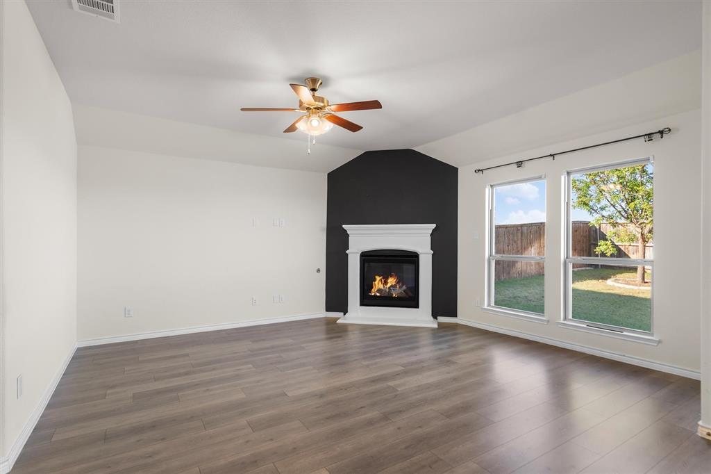 505 Maverick Street Anna, TX 75409 - Photo 12 of 39 a view of an empty room with wooden floor fireplace and a window