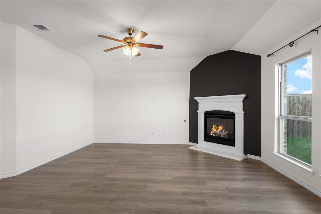 505 Maverick Street Anna, TX 75409 - Photo 13 of 39 a view of empty room with wooden floor fireplace and a window