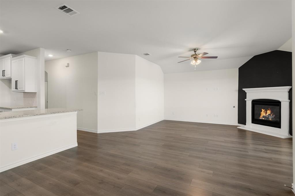 505 Maverick Street Anna, TX 75409 - Photo 19 of 39 a view of an empty room with wooden floor and a fireplace