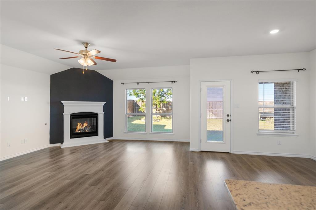505 Maverick Street Anna, TX 75409 - Photo 2 of 39 a view of a livingroom with a fireplace a ceiling fan and wooden floor