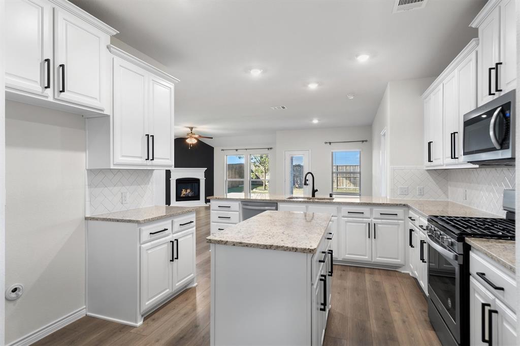 505 Maverick Street Anna, TX 75409 - Photo 23 of 39 a kitchen with stainless steel appliances granite countertop a sink stove and refrigerator