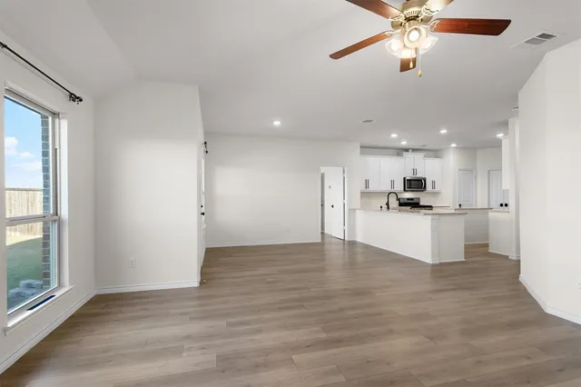 a view of kitchen with kitchen island white cabinets and refrigerator