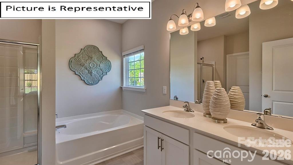 1700 Vanderlyn Street Monroe, NC 28112 - Photo 16 of 19 a bathroom with a granite countertop sink a mirror and a bathtub
