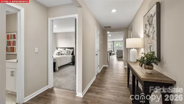 a view of a hallway that has a couch and a dining table with chairs
