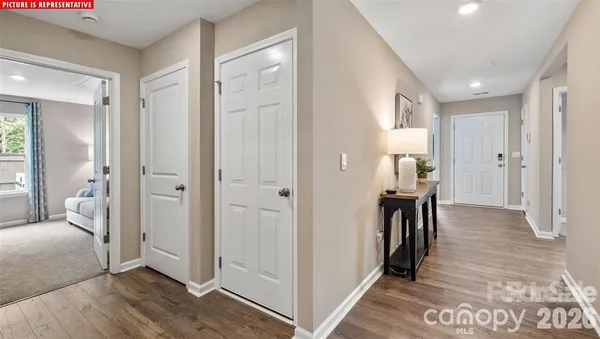 a view of a hallway with bathroom and wooden floor