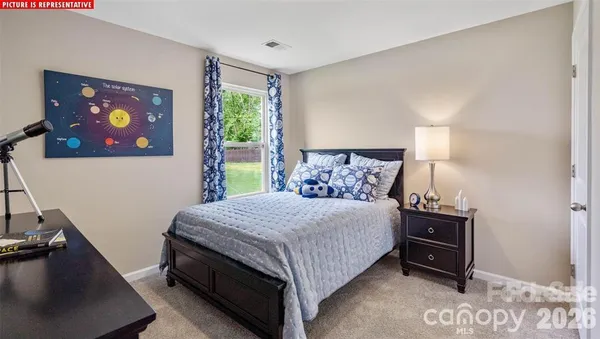 a bedroom with a bed and a dresser next to a window
