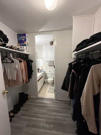 a view of walk in closet with clothes and shoes