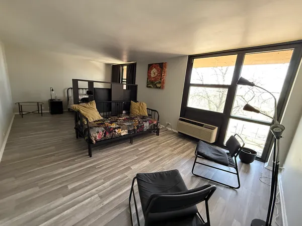 a living room with furniture and a floor to ceiling window