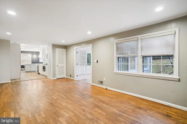 a view of empty room with wooden floor and windows