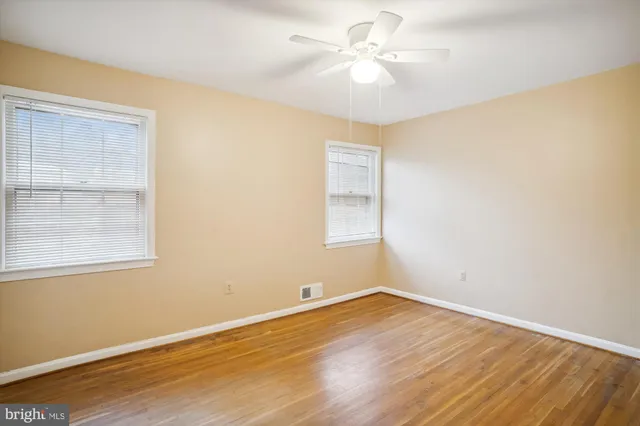 an empty room with a window and ceiling fan