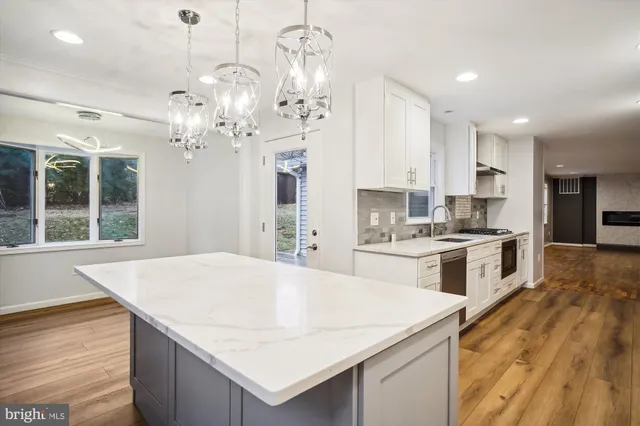 a large kitchen with kitchen island a stove a sink a center island and cabinets