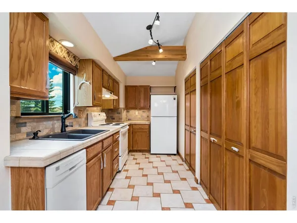 a kitchen with stainless steel appliances kitchen island granite countertop a refrigerator and a sink
