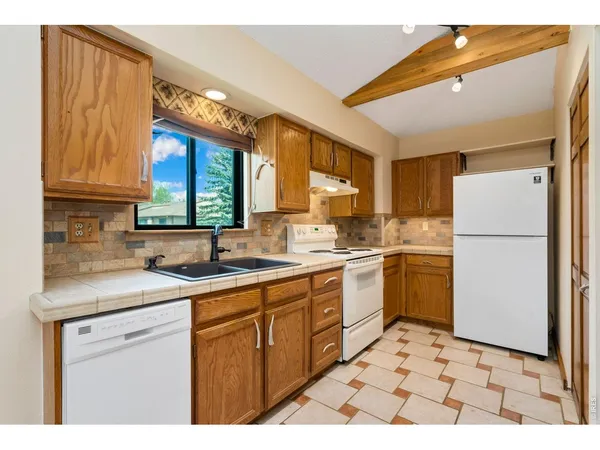 a kitchen with a sink a refrigerator and cabinets