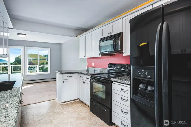 a kitchen with stainless steel appliances granite countertop a refrigerator and a stove top oven