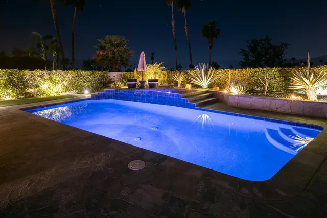 a front view of a house with swimming pool having outdoor seating