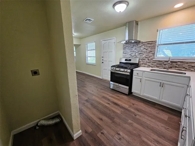 a kitchen with a stove and white cabinets