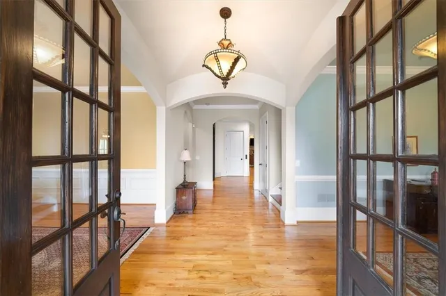 a kitchen with stainless steel appliances granite countertop wooden cabinets a sink dishwasher a stove and a dining table with wooden floor