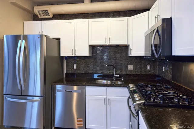 a kitchen with stainless steel appliances granite countertop a refrigerator and a stove