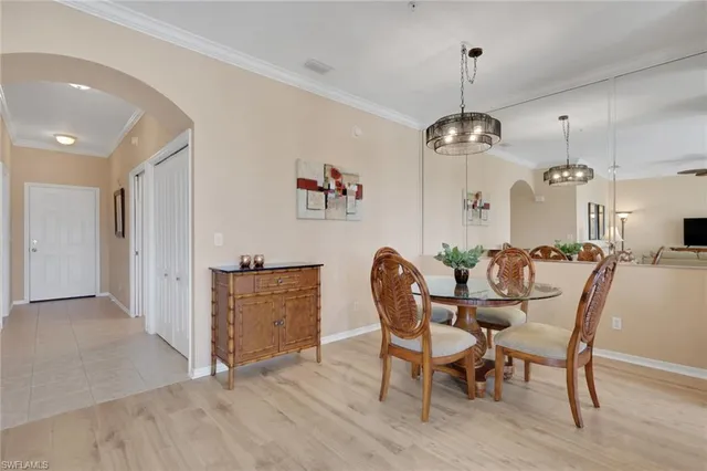 a dining room with furniture a chandelier and wooden floor