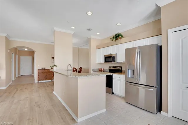 a kitchen with white cabinets and stainless steel appliances
