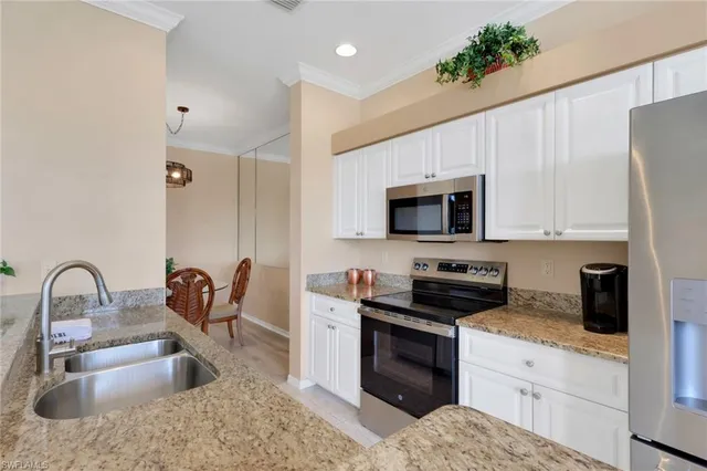 a kitchen with granite countertop a stove a sink and a microwave