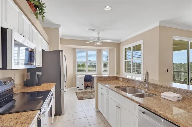 a kitchen with granite countertop a sink a counter top space and stainless steel appliances