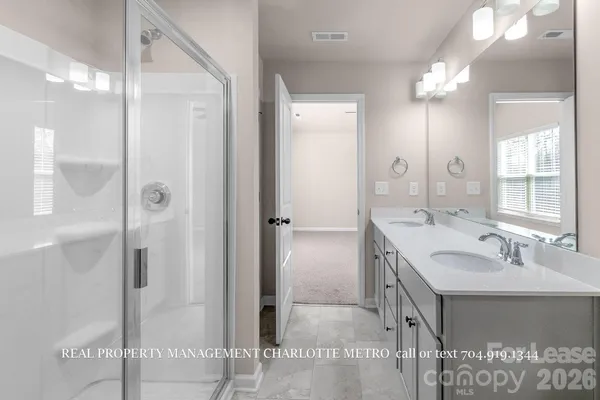 a bathroom with a sink a shower and a mirror
