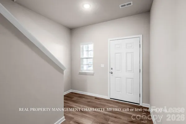 a view of a hallway with wooden floor and staircase